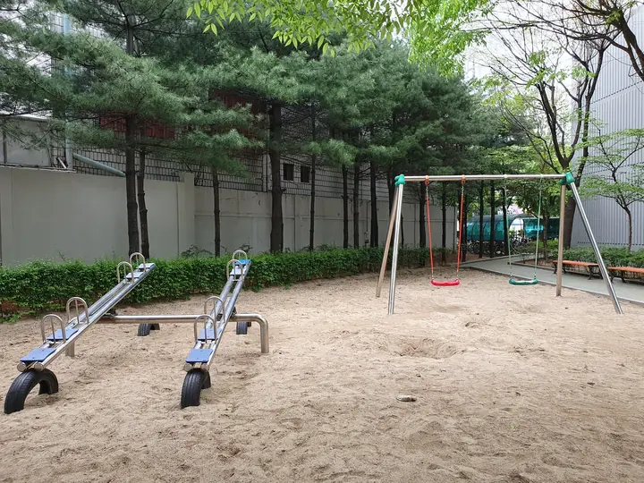 시소와 그네가 있는 모래 놀이터