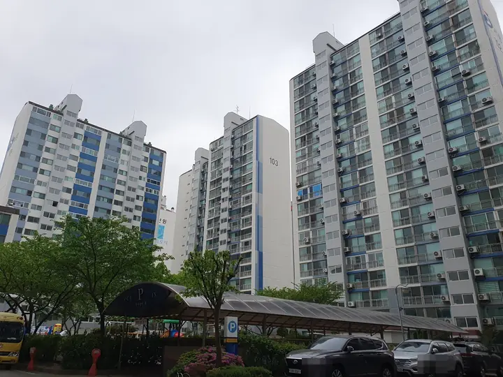 지붕 덮인 주차장 너머 103동