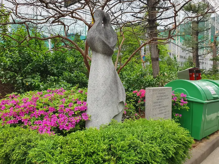 철쭉 화단 위 여인 조형물