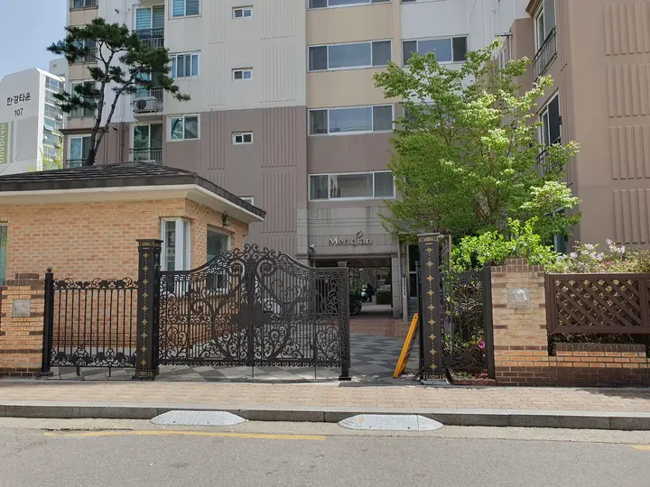 경비실과 철제 대문이 있는 정문