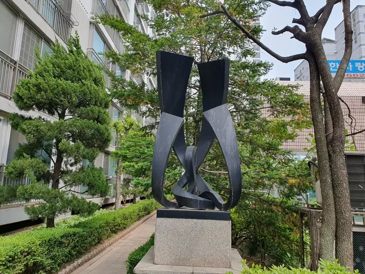 소나무 사이 검은 리본 조형물