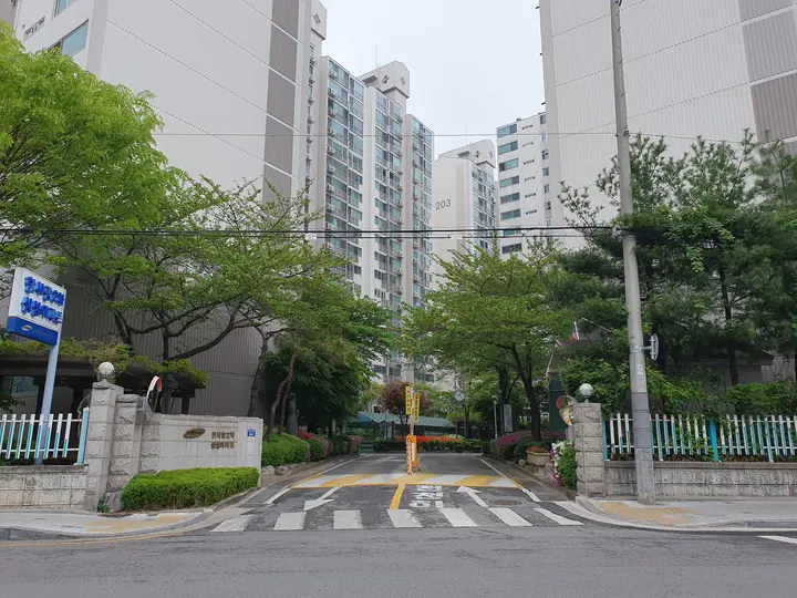 표지석과 철쭉이 핀 단지 진입로
