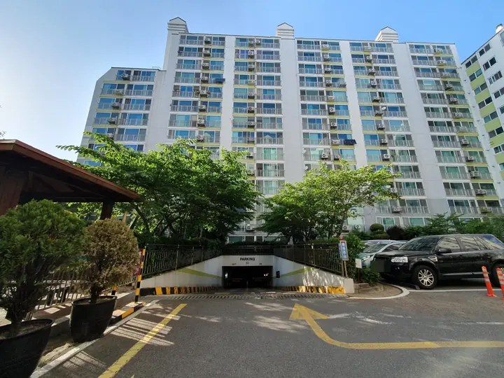 정자와 지하주차장 입구 너머 동 전경