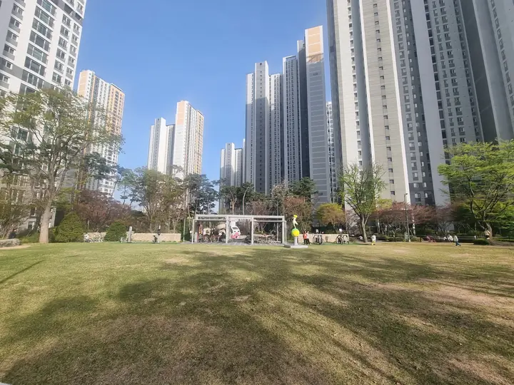 고층 동이 둘러싼 넓은 중앙 잔디광장