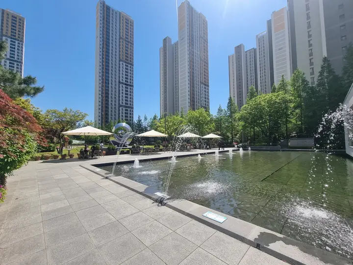 고층 동을 비추는 긴 수경 공간