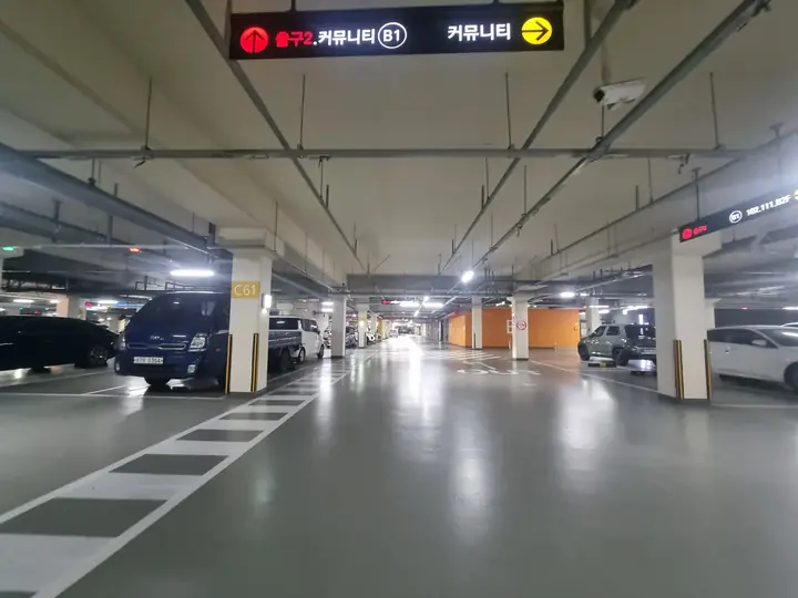 커뮤니티 방향 안내가 걸린 지하주차장