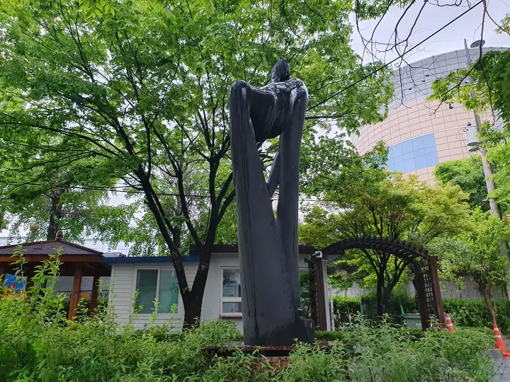 나무 사이 조각상과 아치 퍼걸러